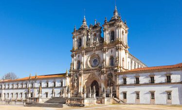 Monastery of Alcobaça in Portugal with its historic Gothic façade under a clear blue sky